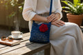 BOLSO TEJIDO A CROCHET AZULINO CON UNA FLOR ROJA